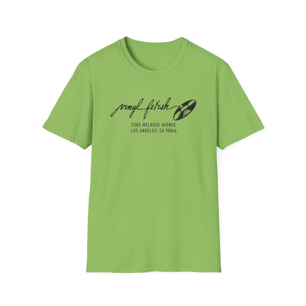 Green t-shirt with black "vinyl fetish 7305 Melrose Ave Los Angeles" graphic.